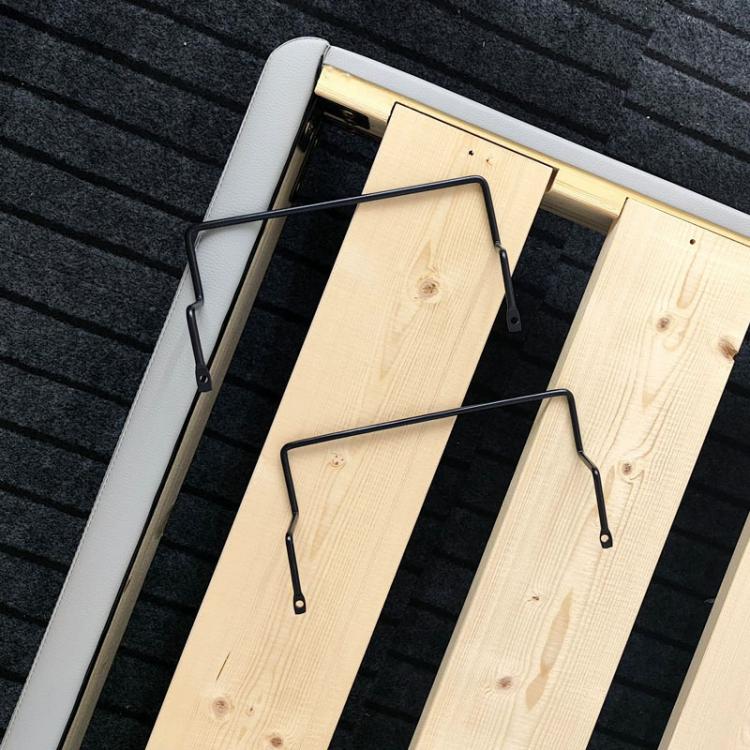 Black anti-slip guardrail strips clipped onto light wood bed frame