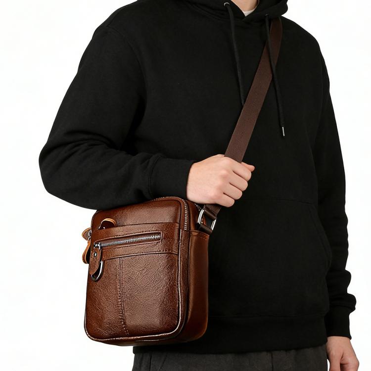 Brown genuine leather crossbody bag worn across the body with front zip pocket