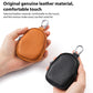 Mini leather coin bag keychains shown in hands: orange and black pebble-grain with zippers