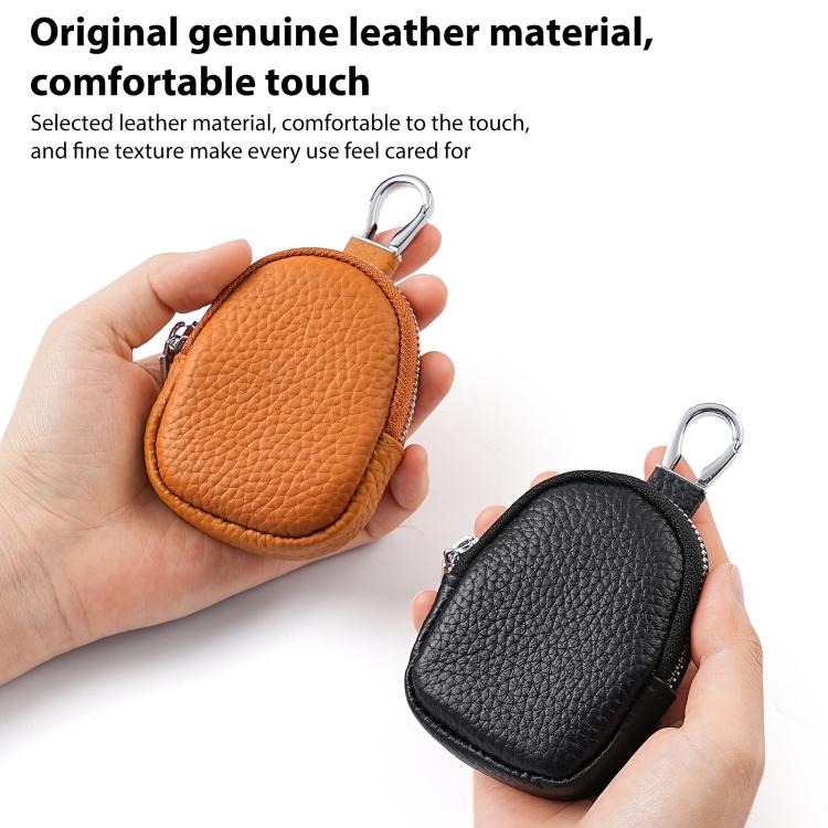 Mini leather coin bag keychains shown in hands: orange and black pebble-grain with zippers