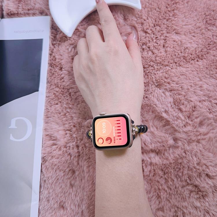 Apple Watch with a black, red, and yellow beaded band worn on a wrist