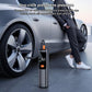 Black digital tire inflator at car wheel with orange button and pressure screen