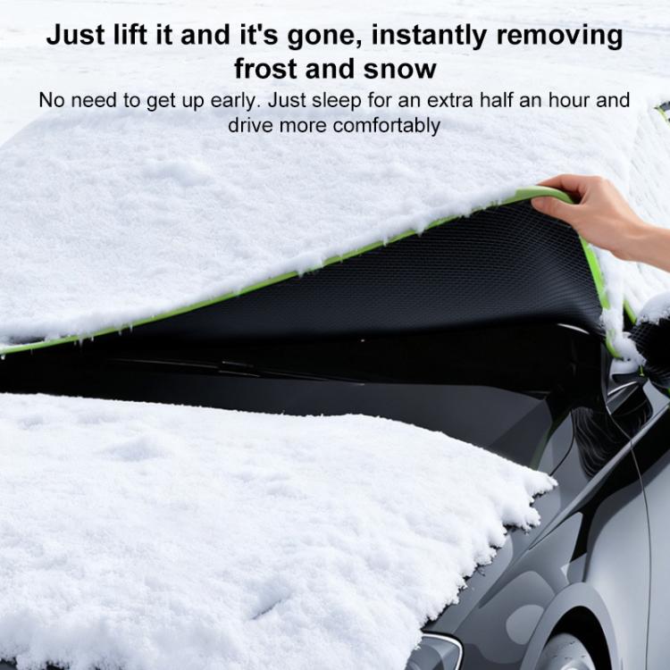Black car windshield half cover with green trim covering snowy windshield