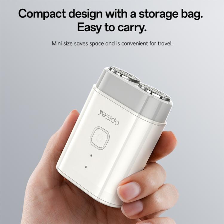 Compact handheld electric shaver held in hand, white body with front power button