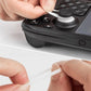 Hand applying a black silicone joystick cap protector onto a game controller stick