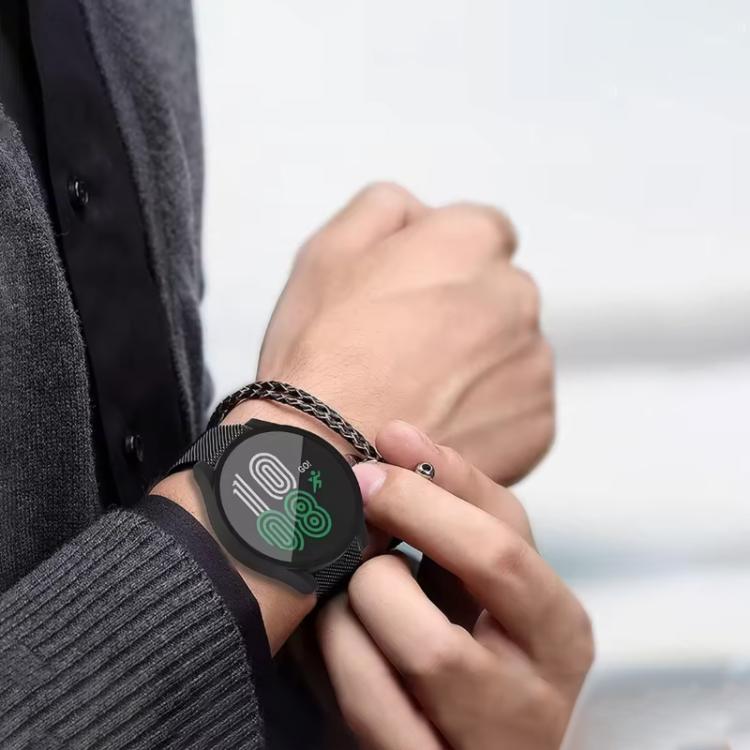 Black round smartwatch with a woven metal band worn on the wrist