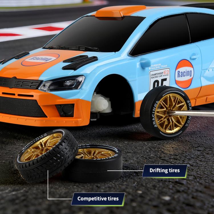 Light-blue and orange RC drift rally car front corner with drifting tires