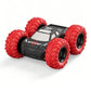 Red RC stunt car with large tread off-road tires and gray-black body paneling.