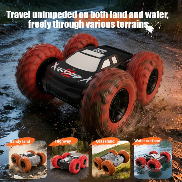 White RC amphibious stunt car with orange wheels driving through wet terrain and shallow water.