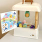 Children's mini claw game machine toy with side door open, showing plush and capsule prizes