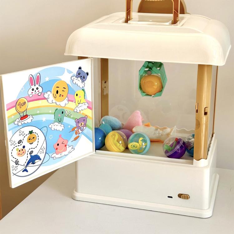 Children's mini claw game machine toy with side door open, showing plush and capsule prizes
