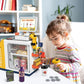 Child playing with yellow self-checkout cash register toy and pretend money coins