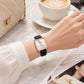 Ladies square quartz watch on wrist: black leather strap, rose-gold case, white dial