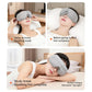 Gray heated eye massager worn on face in a bed setting