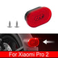 Red oval taillight lens in black housing, close-up with mounting screws