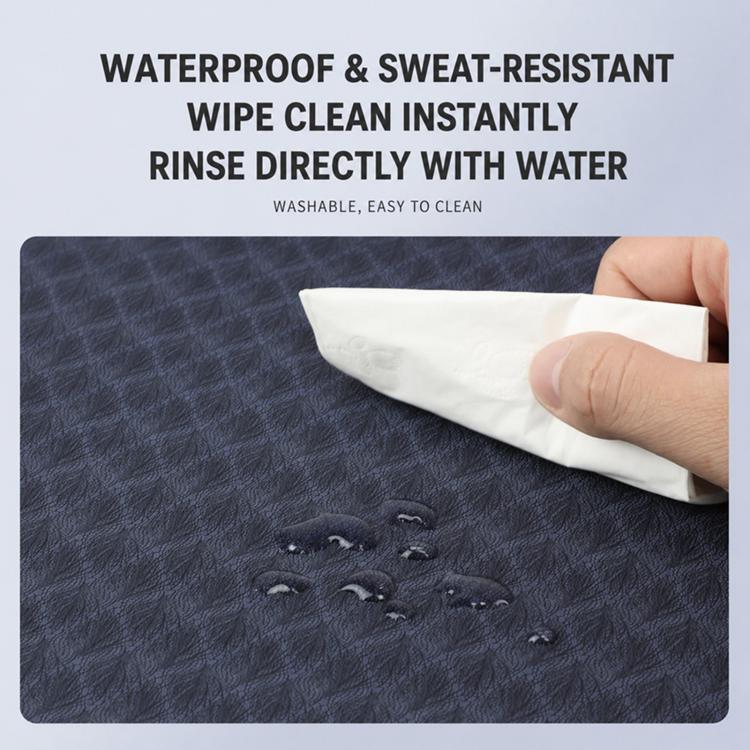 Dark textured yoga mat surface being wiped clean with cloth, red edge visible