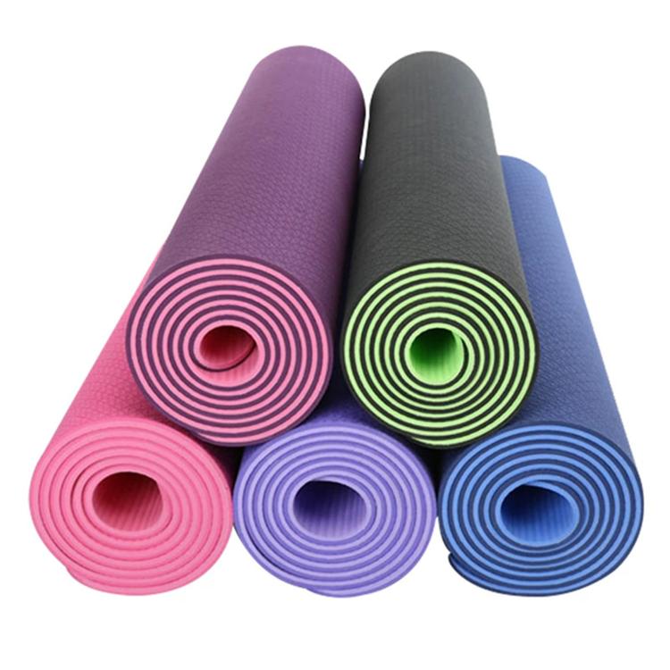 Assorted rolled non-slip yoga mats in pink, purple, green, gray, and blue colors