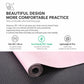 Rolled black microfiber suede yoga mat over pink surface, non-slip texture visible