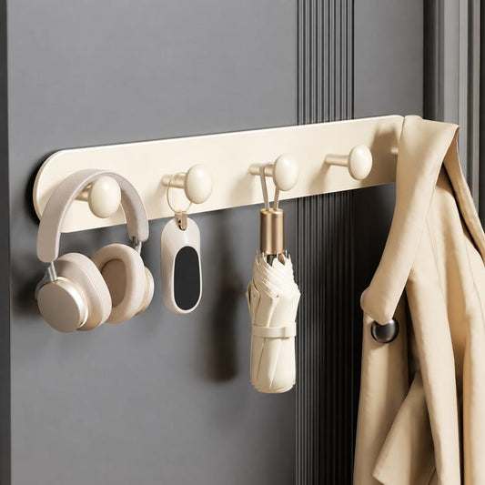 Cream magnetic hook rail on a wall with multiple rounded hooks and hanging umbrella