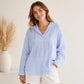Light blue hooded linen sun coat with long sleeves, button front, and drawstring hood