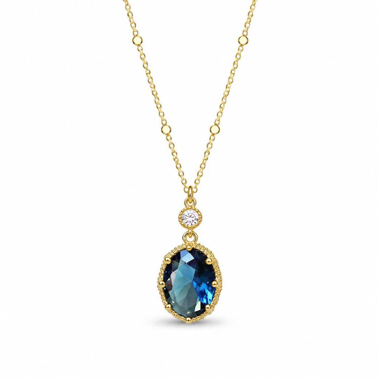 Gold-tone oval pendant necklace with blue teardrop crystal and round clear top