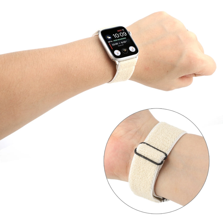 White stretchy nylon Apple Watch band worn on wrist with black clasp