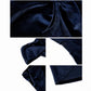 Dark navy velvet dress fabric close-up with draped panel seams and textured sheen