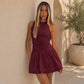 Wine red sleeveless halter short dress with fitted bodice and flared tiered skirt.