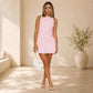 Pink sleeveless halter dress with ruched waist seam and flared layered skirt, above-knee length.