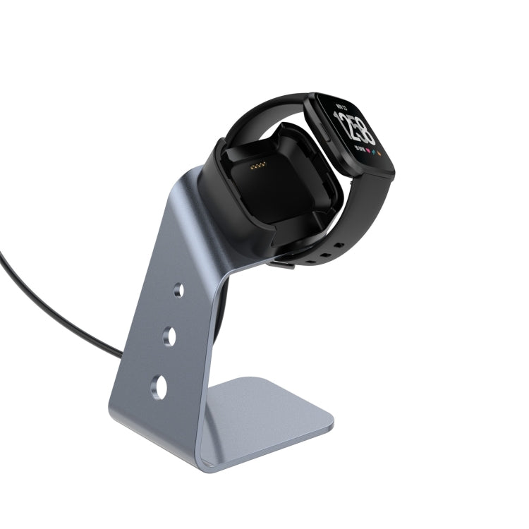 Grey aluminum alloy charger holder holding a watch in the black dock