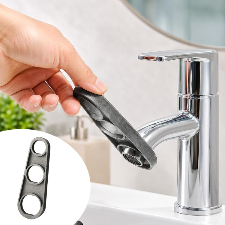 Black carbon-steel faucet bubble wrench held by hand near chrome sink faucet, three sockets