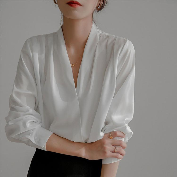 White satin V-neck blouse with long sleeves, vertical drape detail at bodice