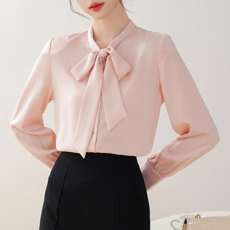 Pink satin bow-tie neck blouse with long sleeves and button front, side view.
