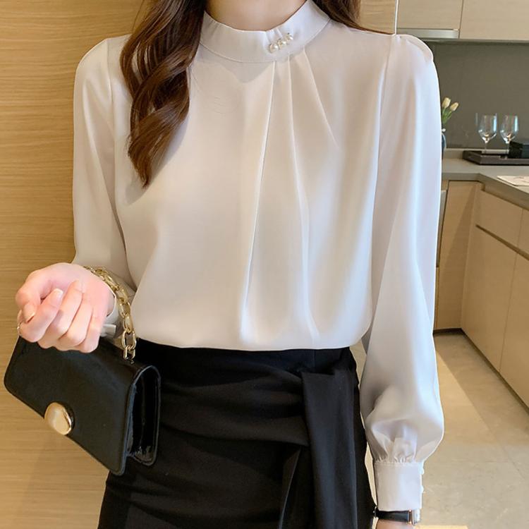 Light-colored chiffon blouse with mock neck and pearl button detail