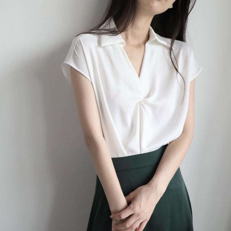 White twist V-neck cap-sleeve blouse showing draped neckline and soft collar