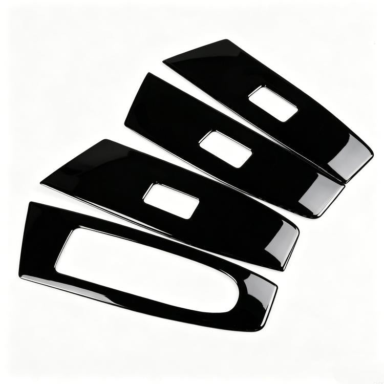 Four black window lift switch trim inserts with white rectangular cutouts