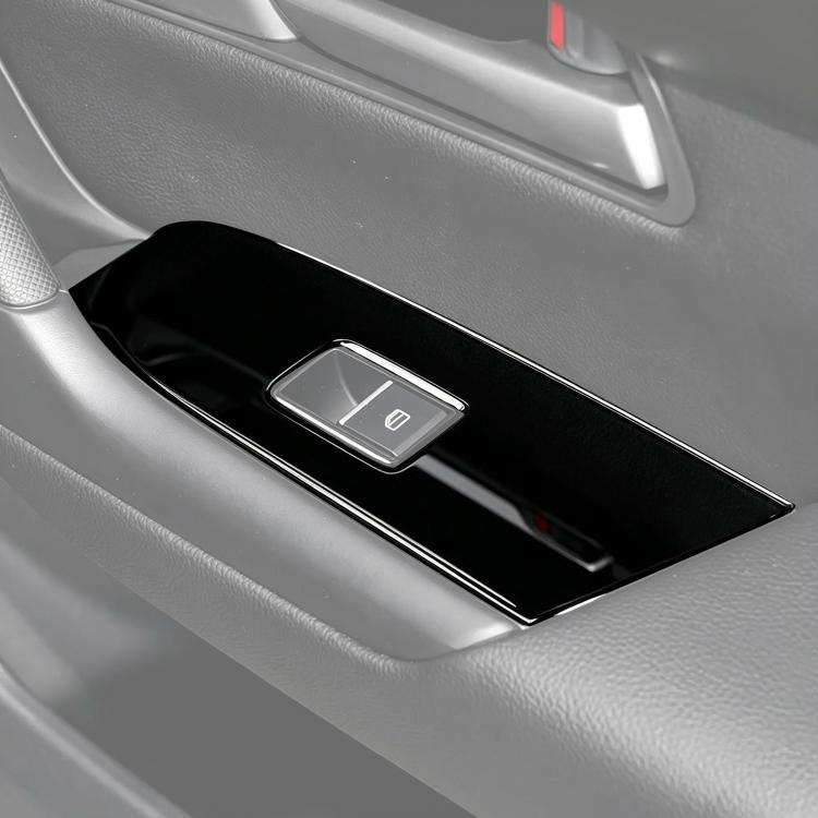 Black window lift switch trim panel with silver button outlines on car door
