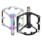 Rainbow and black mountain bike pedals, each with dual platform and axle