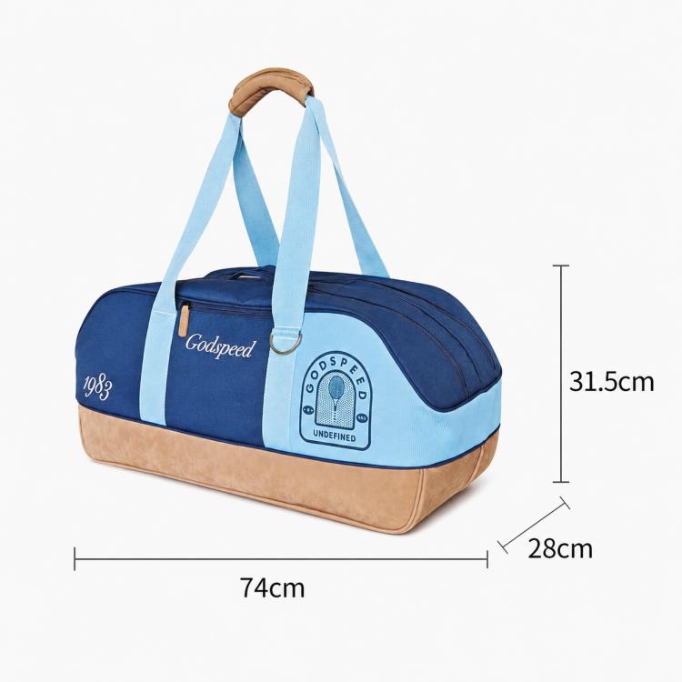 Blue sports tote bag with light blue straps, tan bottom, front pocket, circular Pelta patch.