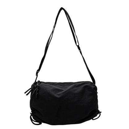 Black nylon drawstring crossbody bag with adjustable shoulder strap and cinch closure