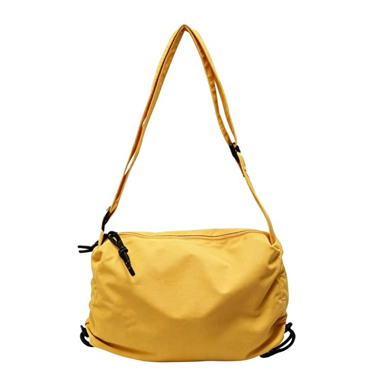 Yellow nylon drawstring crossbody bag with adjustable shoulder strap and cinch closure