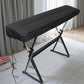 Black dustproof piano keyboard cover with drawstring, fitted over electronic keyboard stand.