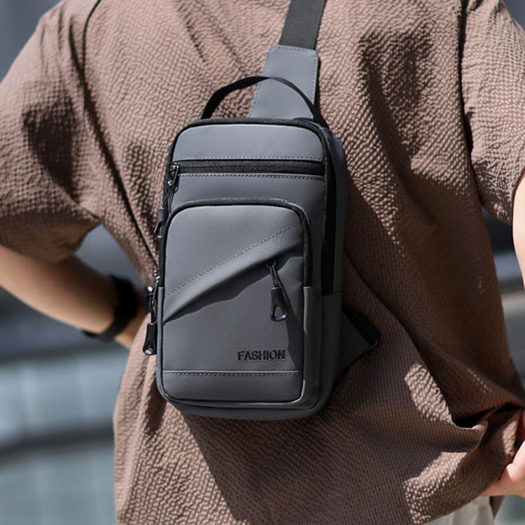 Grey crossbody chest bag worn on chest with adjustable strap and front zipper pocket