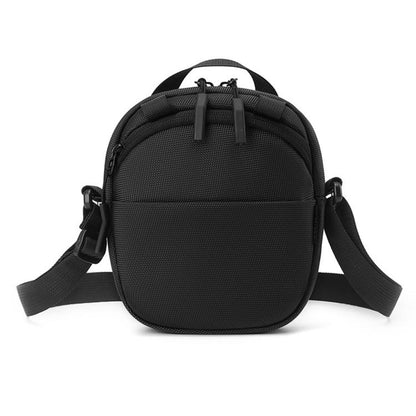 Black round nylon crossbody bag with adjustable shoulder strap and front zipper pocket