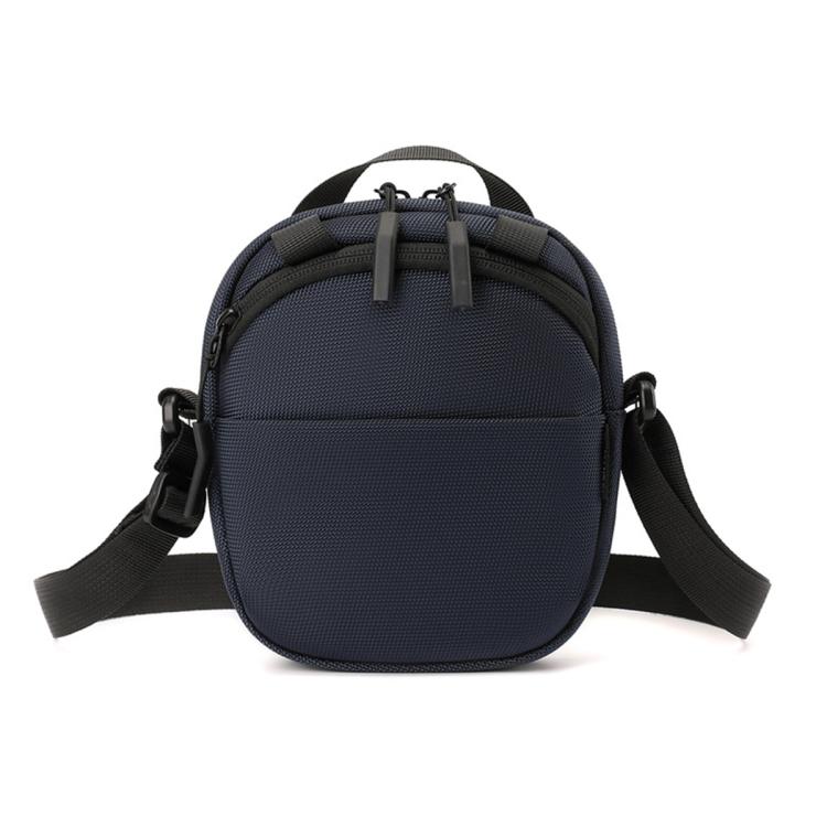 Navy blue round nylon crossbody bag with adjustable shoulder strap and front zipper pocket