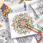 Colorful mandala flower design page with colored pencils on top of other sheets