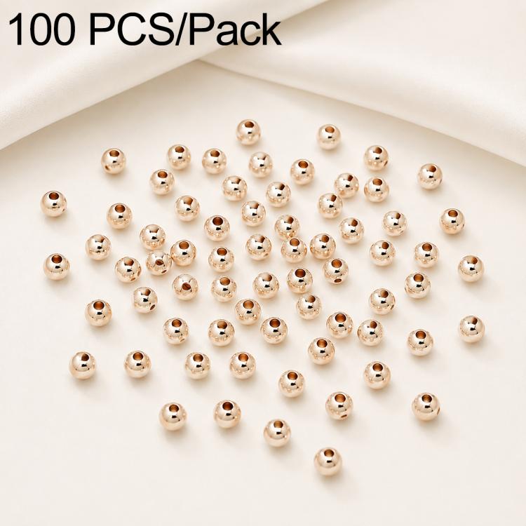 Gold-plated round spacer beads with visible straight holes, smooth round form; bulk spread.