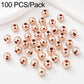 Rose-gold round spacer beads in a spread arrangement, smooth finish, 100-pack