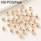 Gold-plated round spacer beads, smooth finish and straight holes; close-up of scattered beads.