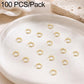 Gold open jump rings, small split loops scattered across a round dish